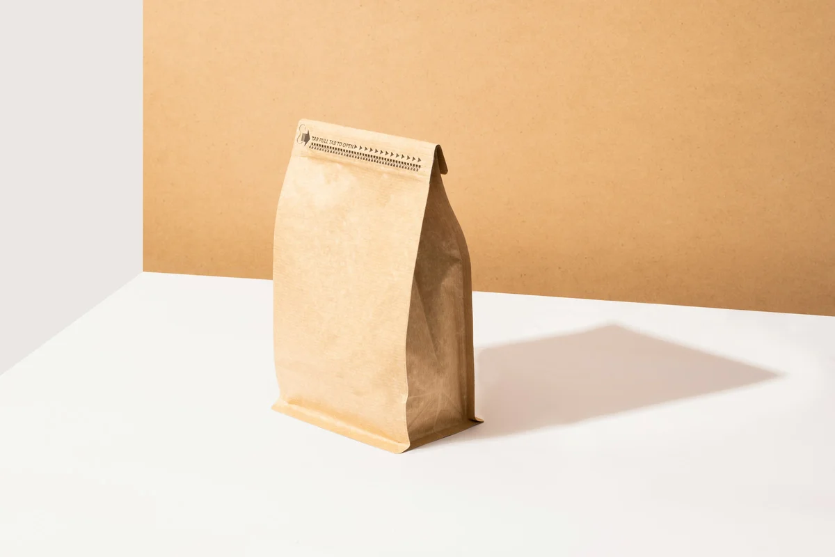 Kraft paper packaging shot on a tan backdrop with a cast shadow before AI background removal