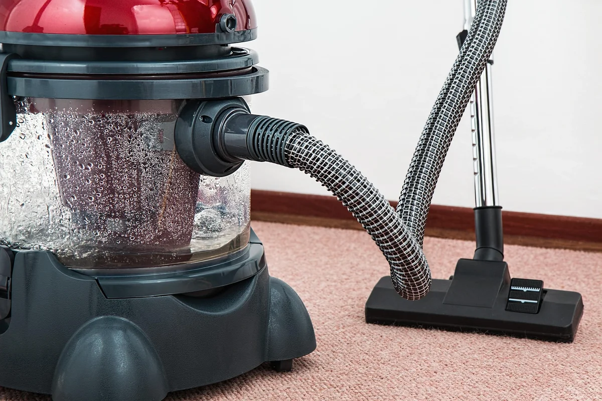 Vacuum cleaner photographed on carpet in a room before AI background removal