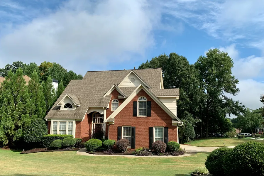 Exterior real estate photo before sky replacement — dull grey overcast sky